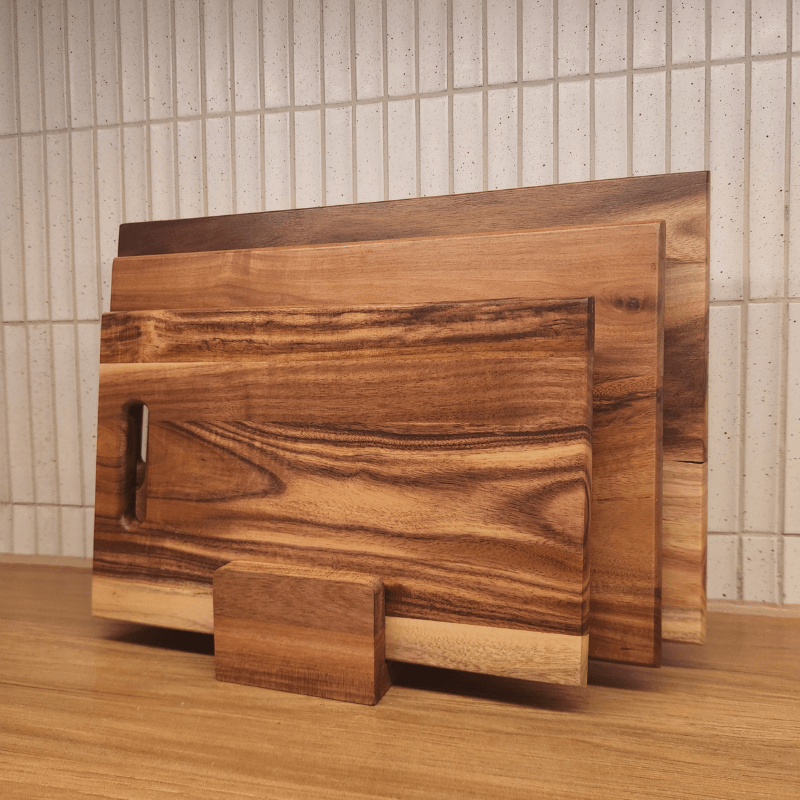 Set of wooden cutting boards on a wooden surface with a tiled wall background