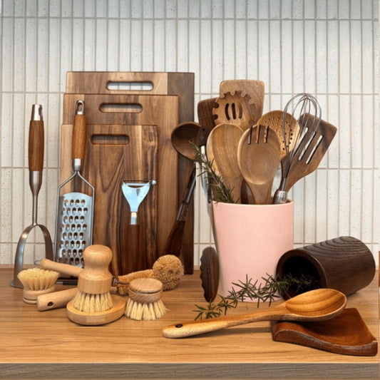 Collection of kitchen utensils and tools on a wooden surface with text 'The Whole Kitchen Reset Bundle'.