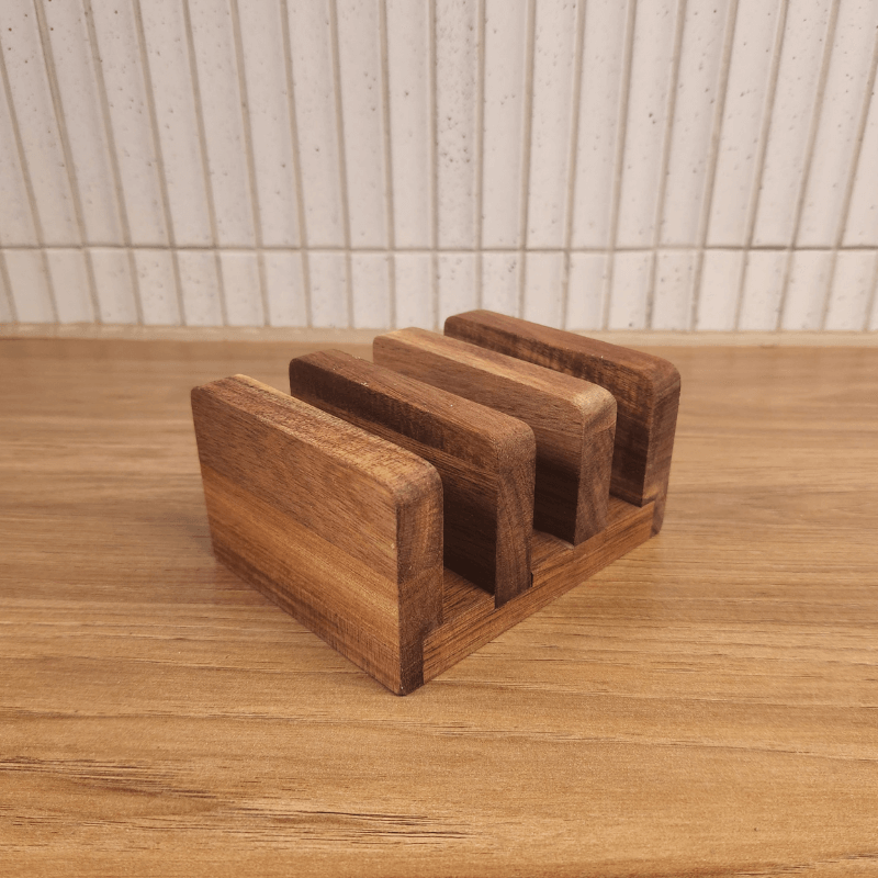 Acacia Board Stand with three slots holding cutting boards upright on wooden surface
