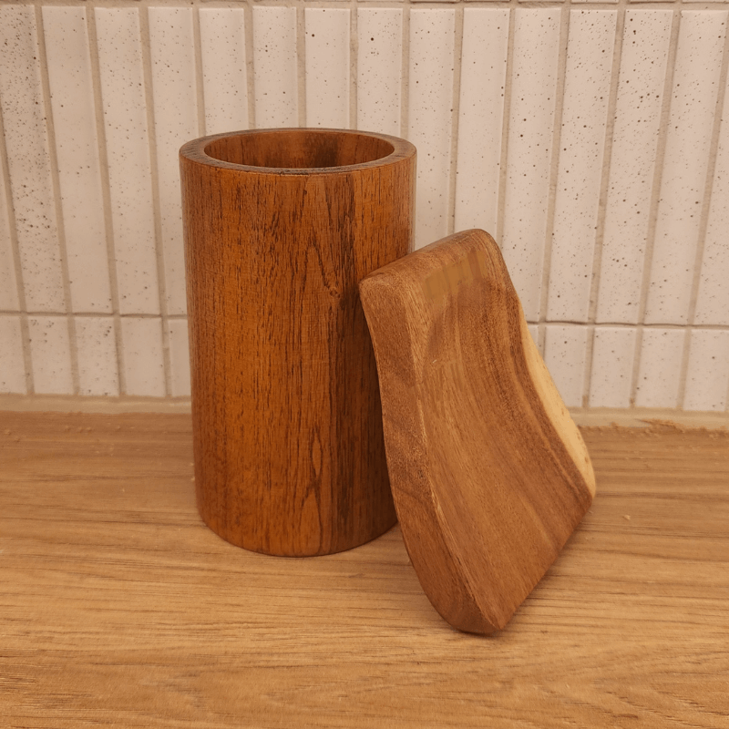 Wooden cylindrical container with a lid on a wooden surface