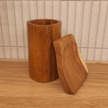 Wooden cylindrical container with a lid on a wooden surface